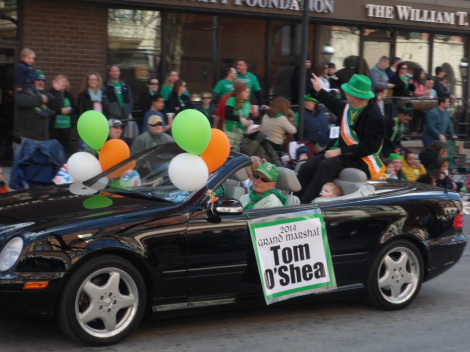 The 2014 Grand Marshal Tom OShea waves and smiles at the crowd, while the crowd goes wild and says hello to OShea. 