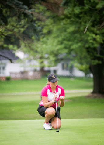 Girls golf player Michaela McQuaig lines up her ball during an intense tournament.  Girls golf has changed a lot this year due to the new PIAA rules.