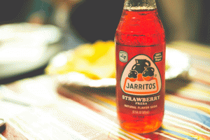 Enjoy a refreshing fruit soda, like this strawberry one from Jarritos, with your meal.