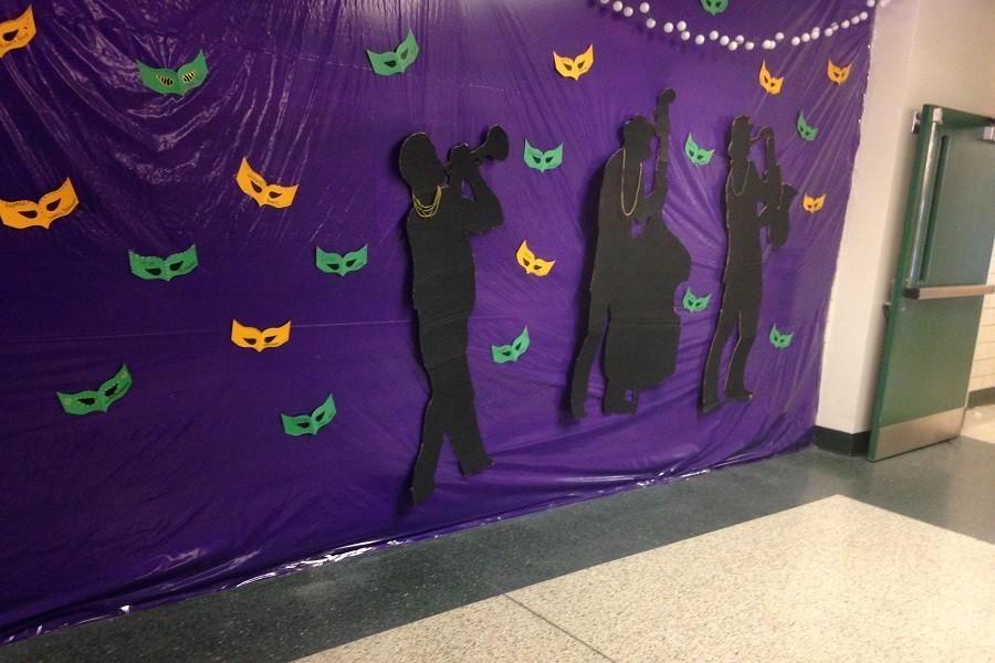 Many Mardi Gras themed decorations are hung up around and inside of the gym.