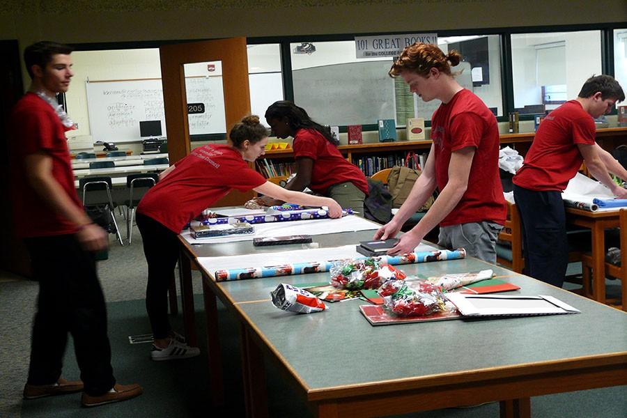 Jules Harper-McCombs wraps books for the Adopt a Family program, while other Senior Class Council members continue to work hard as well.