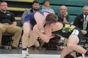 Coach Joe Wilson (back, second from left) looks on with the other coaching staff as senior Grant Shughart attempts to tackle his opponent from Red Land during a match on Dec 23.  Wilson earned his 100th win earlier this season as a coach when Carlisle took on Harrisburg.