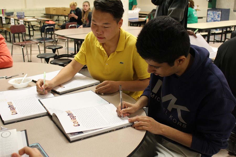 Seniors Ted Galbadrakh and Basel Alshalawi sign their friend's yearbook.