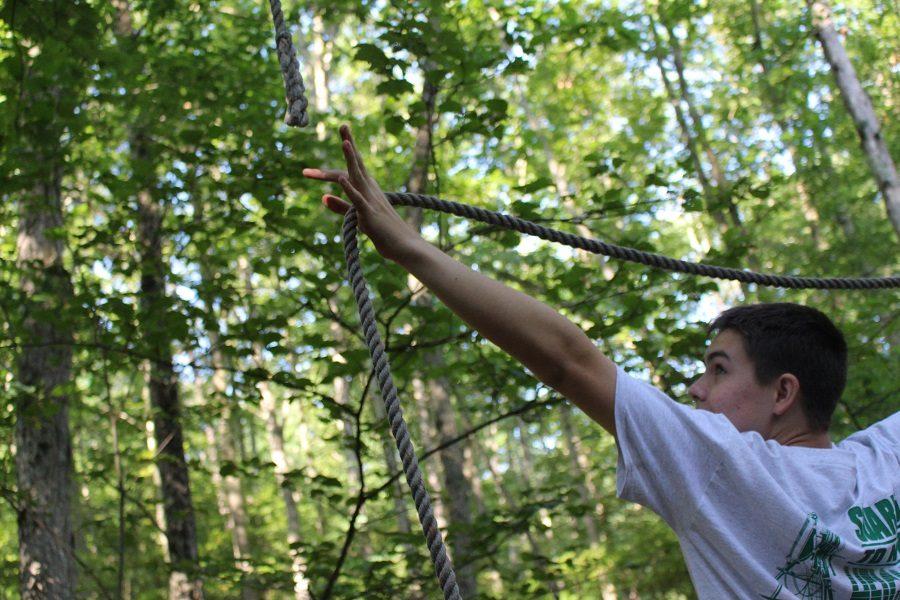 On the low ropes course students Reach for New Heights to help get through the mildly challenging course.