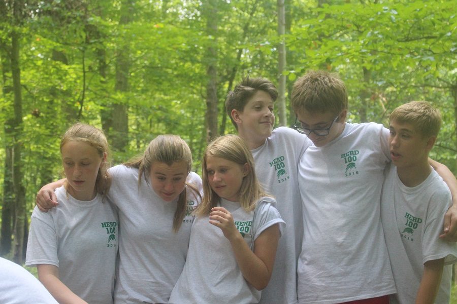 Team members huddle close to make sure the Teter Totter remains in balance.