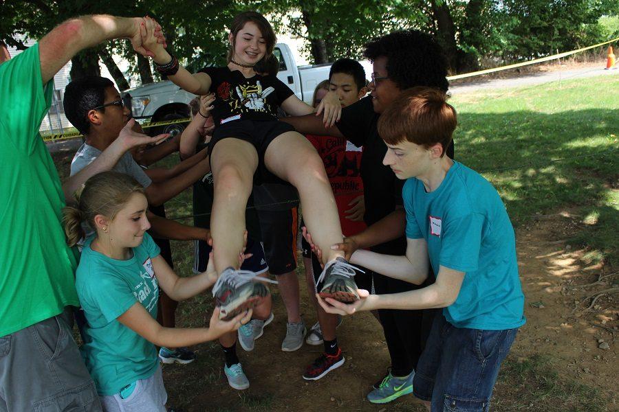 Members of this team work together to get each other over the "laser" safely without setting it off.