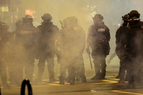 Police fire teargas as protestors converge on downtown following Tuesday's police shooting of Keith Lamont Scott in Charlotte, N.C., Wednesday, Sept. 21, 2016. (AP Photo/Gerry Broome)