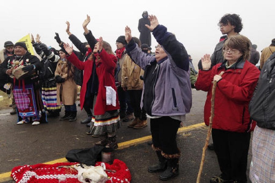 Protesters against the construction of the Dakota Access oil pipeline block a highway in near Cannon Ball, N.D., on Wednesday, Oct. 26, 2016. Law enforcement officials have asked people protesting the Dakota Access oil pipeline to vacate an encampment on private land, and the protesters said no. Protesters are trying to halt construction of the pipeline they fear will harm cultural sites and drinking water for the Standing Rock Sioux. (AP Photo/James MacPherson)