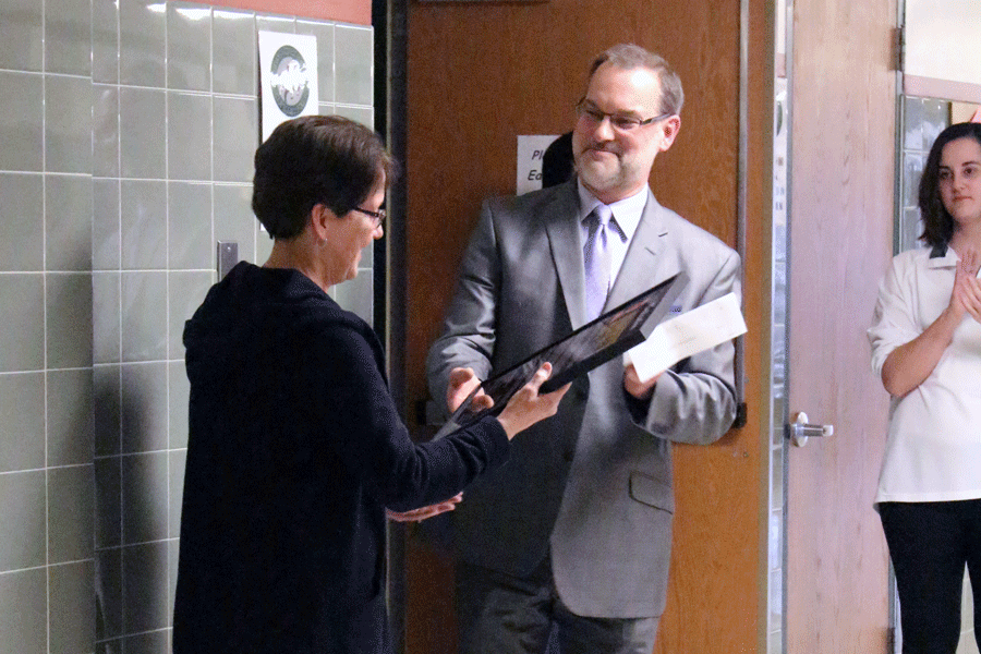 CHS principal Jay Rauscher presents Biondo-Hench with a dedication plaque for the new display.