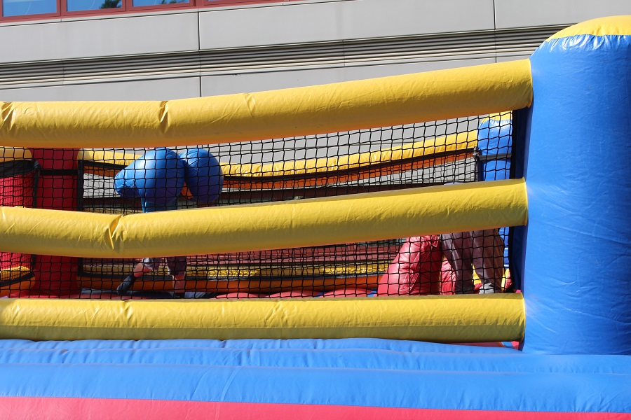 Freshman JJ Carter and Chris Patton throw punches with blow up boxing gloves at Spring Fest.