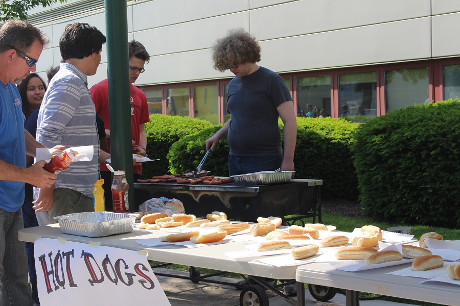 Harrison Wendelken mans the grill, making hotdogs and passing them out to everyone lined up.