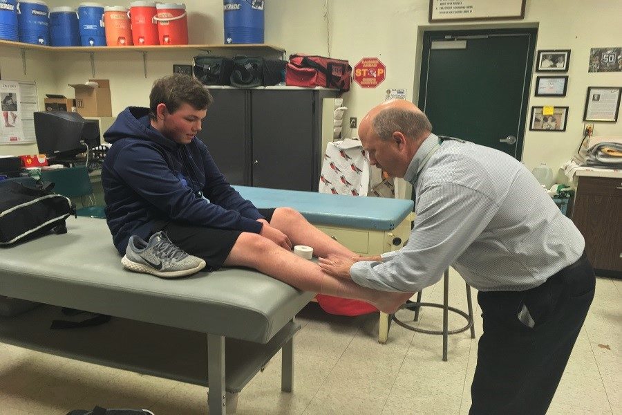 Brain Waiter works with a student athlete. Trainers do a lot in our school to keep athletes healthy.