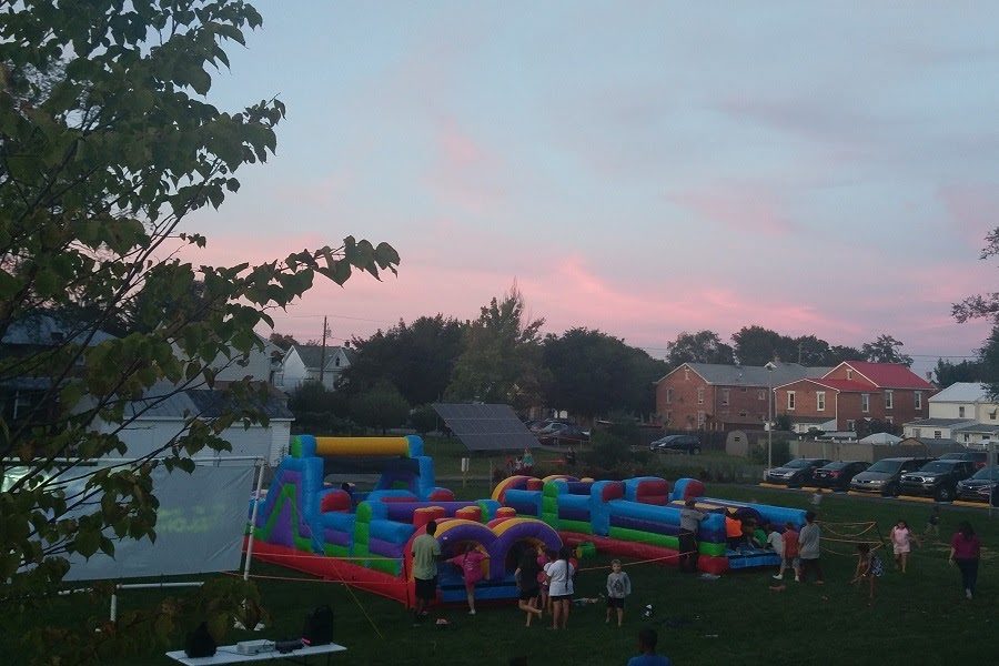The sun sets on the bouncy castle at Taking it to the Streets. After sundown, a movie was shown to the children at the event.