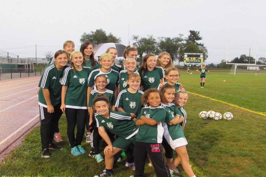 The Carlisle Area Youth Soccer (CAYS) teams pose before walking the Carlisle High School girls soccer team out onto the field. The CAYS program prepares girls to play at the high school level.