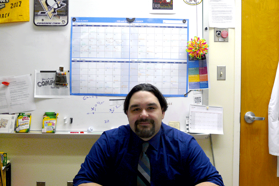 Physics teacher Robert Urban sits at his desk in his classroom. 