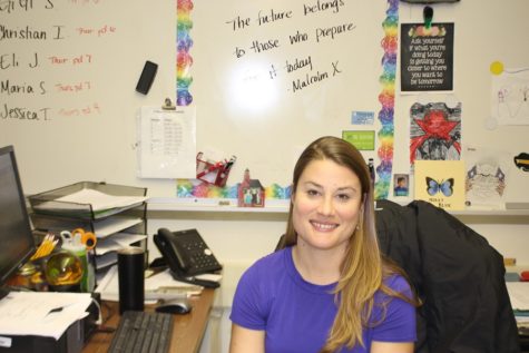 Delia Roper sits at her desk in M209. She teaches World History and Honors World History.