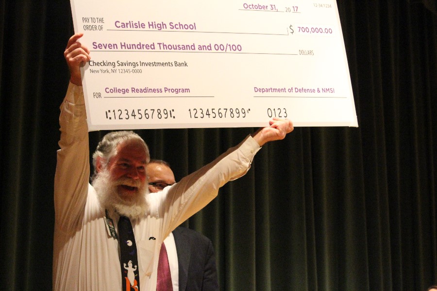 Robert Barrick lifts the NMSI check into the sky at the ceremony for the grant October 31. Barrick's class was one of the classes that benefits from the grant.