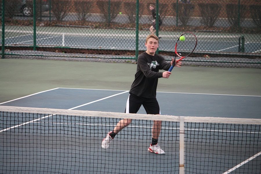 Sean Bergsten takes a volley at the net in his doubles match.