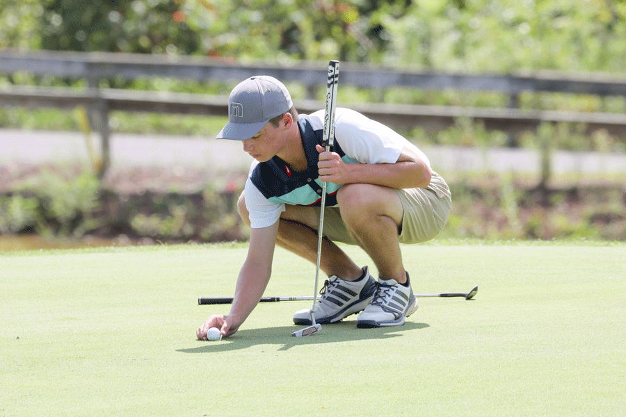 Senior Strider Jacobson places his ball down for a putt.  Jacobson was one of the top performers for the golf team this year.  He qualified for the Mid-Penn Championship tournament, where he placed 62nd out of 92 golfers.