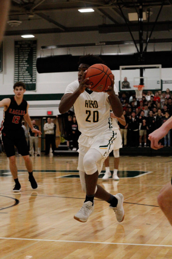 Leap Of Faith: #20 Varsity Kurtis Ravenel dribbles to the net, ready to score some points for Carlisle. 