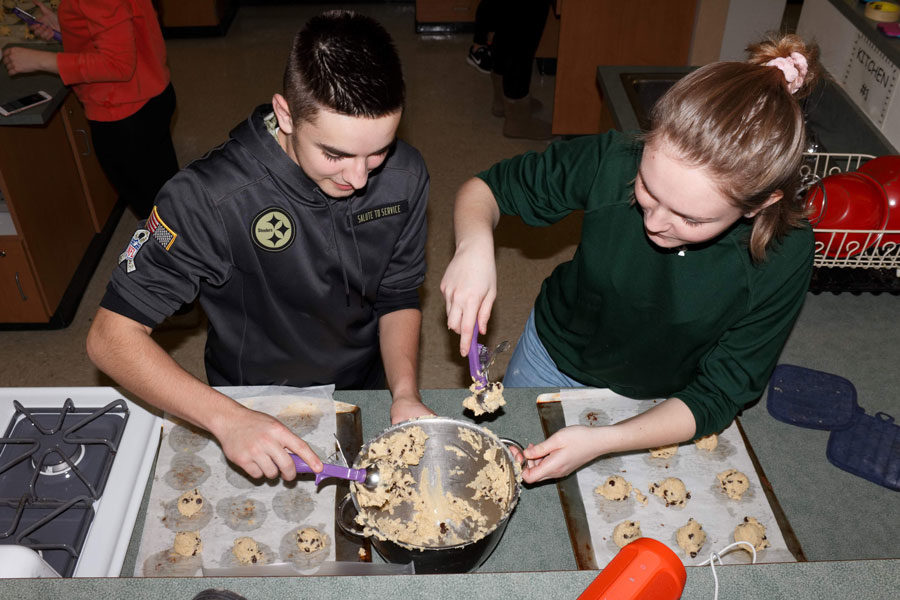 Junior MJ Brown and sophomore Mabel Sheesley scoop chocolate chip cookie dough onto baking sheets.  Student Council made 130 dozen cookies for this years Project Share collection.