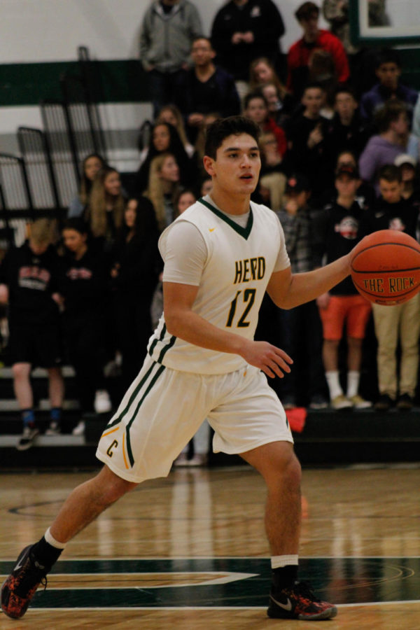 Patience: #12 Varsity Ben Nix dribbles down the court, waiting to pass to his teammates. 