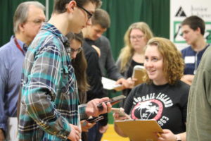 Micah Webb, Lauren Waring, and Paige Wood use their phones to figure out the cost of a vacation during the 2017-2018 school year. This years junior class will participate in Junior Achievements Real Life program on Feb 26-27.