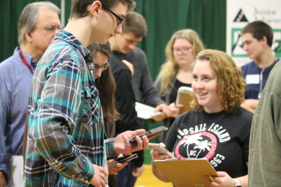 Micah Webb, Lauren Waring, and Paige Wood use their phones to figure out the cost of a vacation during the 2017-2018 school year. This years junior class will participate in Junior Achievements Real Life program on Feb 26-27.