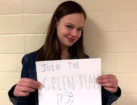 Morgan Leshniowsky, a member of the Green Team, holds a poster for the organization. The team is currently. looking for more members.