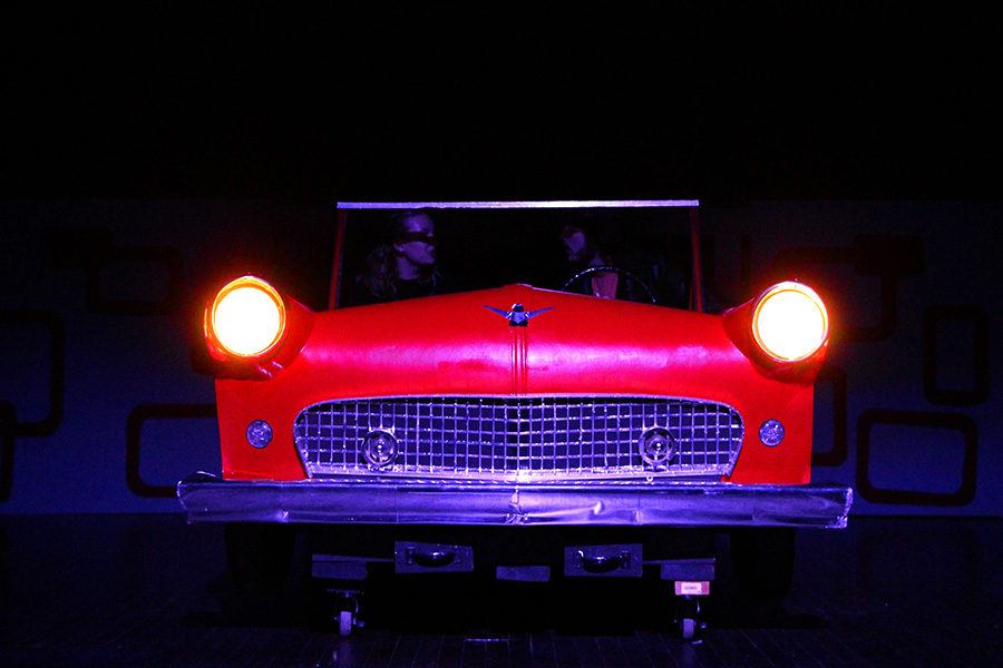 Ashlyn Ashmore (Sandy) and Cameron Fritz (Danny) rehearse a scene at the drive-in.  There are many props that were created for the musical and are being used as key components of the musical like this red car.
