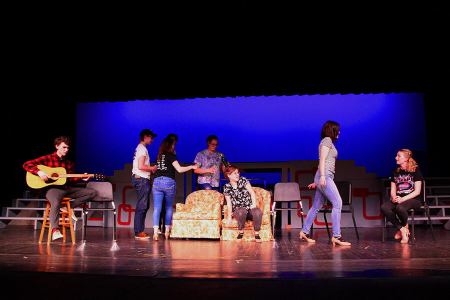 The cast sets up a party scene on stage. There will be many musical numbers from "Grease" that include "Grease Lightnin'" and "You're the One That I Want."