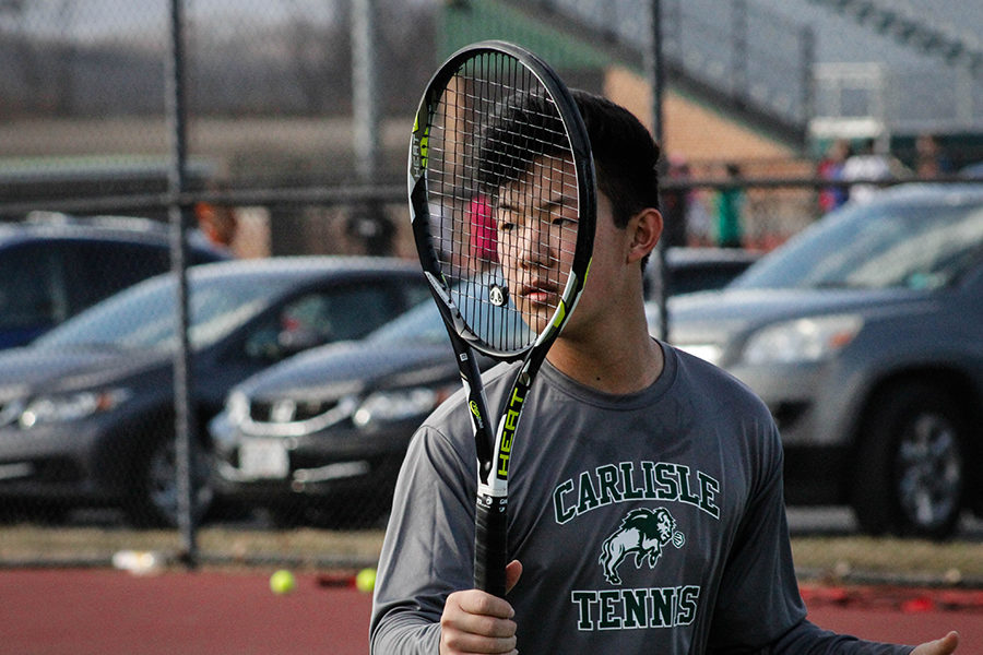 Varsity player Ryan Jin readies his racket to hit a volley over the net. Jin is a junior this year and is on the 1st doubles team with Brady Chilson. 