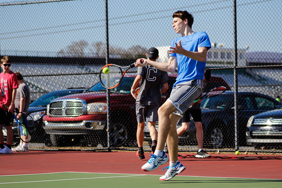 Varsity player Jessie Beck hits a tennis ball during a ground-stroke drill. The boys drill for an hour, practicing their shots before they play against one another. 