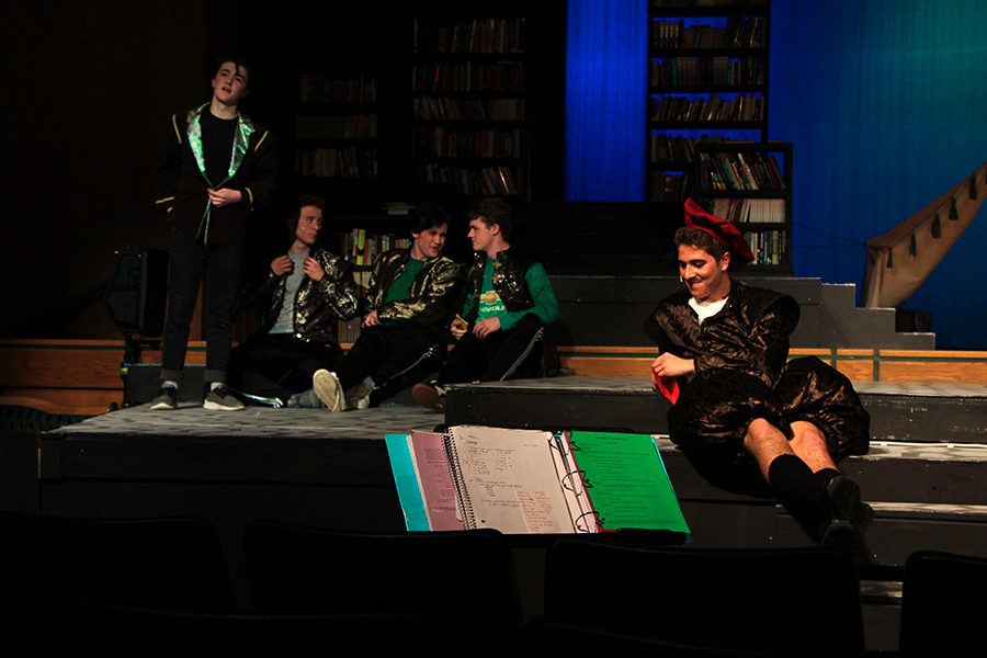 The soccer players (left) swoon over the Shakespeare students they have fallen for. They see an opportunity to talk to the girls teacher Armado, played by Bennette L Solomon (right)