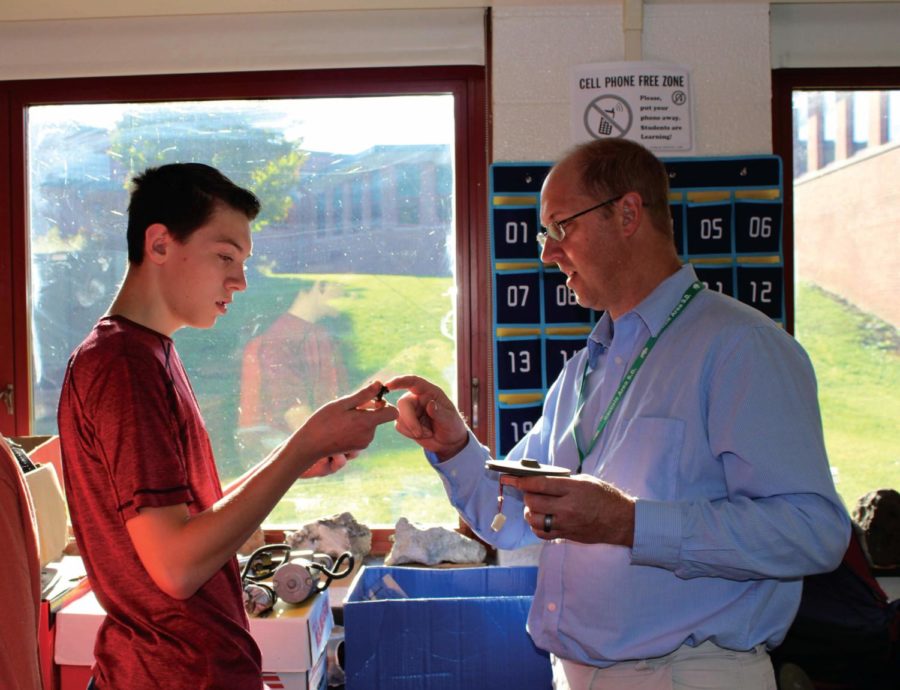 Freshman Jacob Murphy and geo-enviroemntal teacher William Bechtel work together to find the right parts for Murphy's BattleBot during a club period.