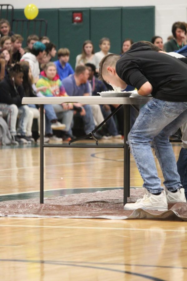 Senior Marty Brown smashes his face into a pie during the pie eating contest.  All members of the winterball court participated in a pie eating contest during the pep rally. 