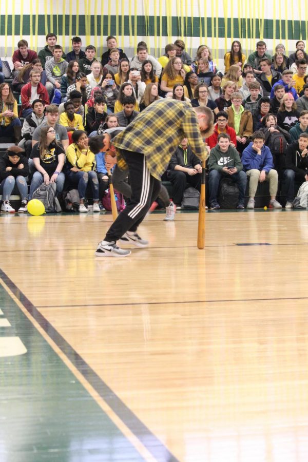 Sophomore Carter Smith spins in a circle with his forehead on a bat.  Smith was chosen to participate as an outstanding athlete. 