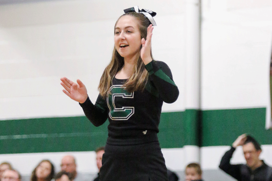 Senior Jenna Trolinger cheers on the crowd at a recent boys basketball game. Trolinger is one of the teams flyers, which means she is hoisted into the air to do stunts.