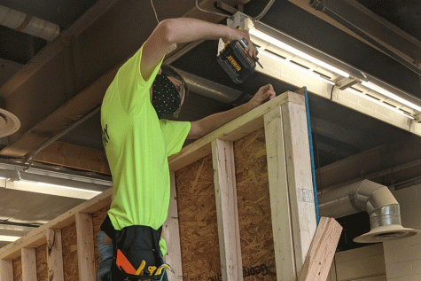 TOUGH AS NAILS: Sophomore Lucas Sandoval climbs to great heights to practice drilling in Carpentry I. The Carpentry classes have to obey the precautions of Covid-19 like wearing a mask and spacing far apart.