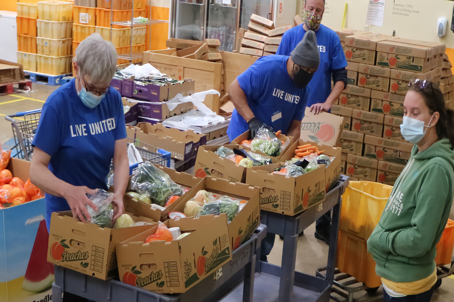 WORKING TOGETHER: Volunteers at the Project SHAREs warehouse package fruits and vegetables for the families they serve. Since the pandemic started, the food bank has seen an 18% increase in households served.