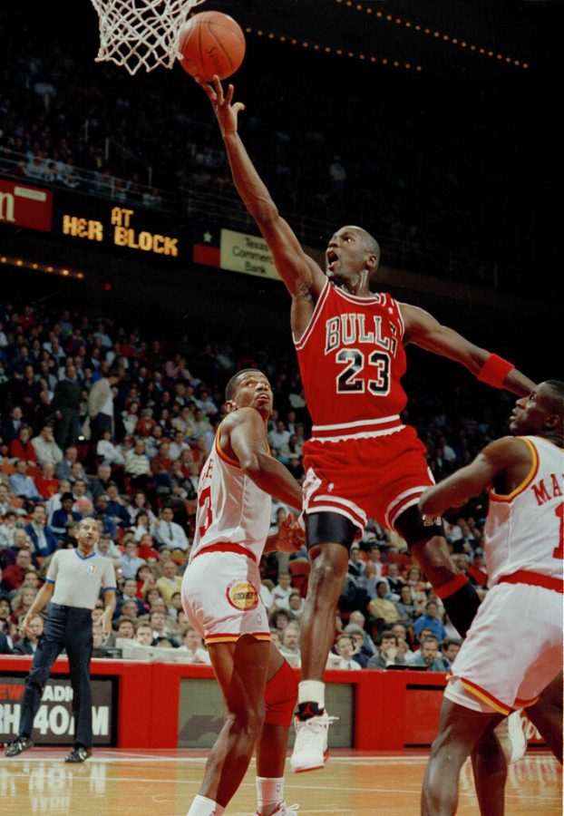 FILE - In this Jan. 3, 1991, file photo, Michael Jordan (23) of the Chicago Bulls drives the lane for a finger roll lay-up over Otis Thorpe, left, and Vernon Maxwell, right, of the Houston Rockets in the first half in Houston, Texas. Picking the car number for Michael Jordans new NASCAR team was a slam dunk: Bubba Wallace will drive the No. 23 car when the team makes its debut next season. (AP Photo/David Scarbrough, File)