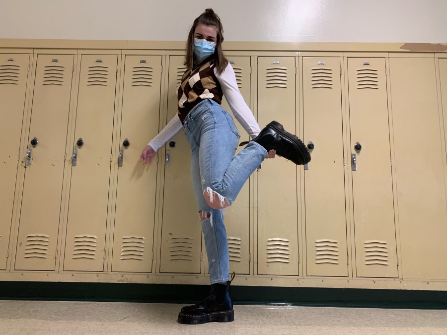 Kathleen ONeill strikes a pose in her layering outfit example. Turtlenecks and long-sleeve shirts have become staple items that get worn over top sweater vests, tank tops, band tees, etc. She is also rocking another popular item, Doc Martens. Style icons such as Emma Chamberlain have inspired these styles. 