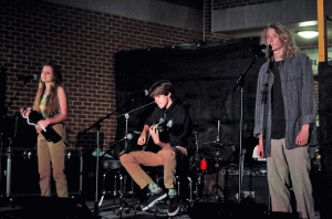 FLOORING AUDIENCES: Senior Renee Blacksmith and juniors Charlie Carlton and James Crawford take to the stage at the First Cup Coffeehouse performance night. Members of the band "Under the Floorboards," they performed "Somethin’ Stupid” by Frank and Nancy Sinatra. 