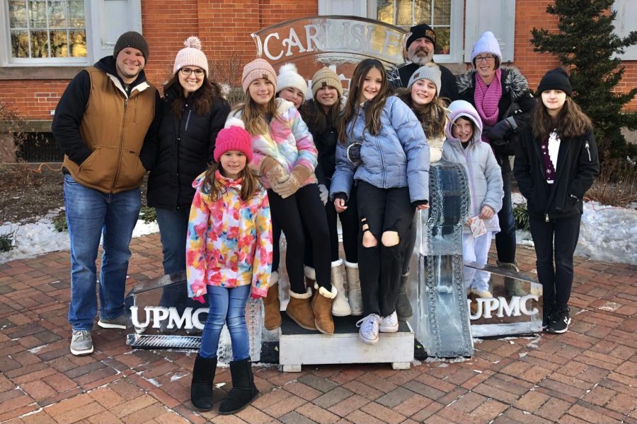 SAY 'FREEZE': A local family poses for a group shot with the traditional ice chair in the town square. This is a popular destination for those visiting the annual festival.  