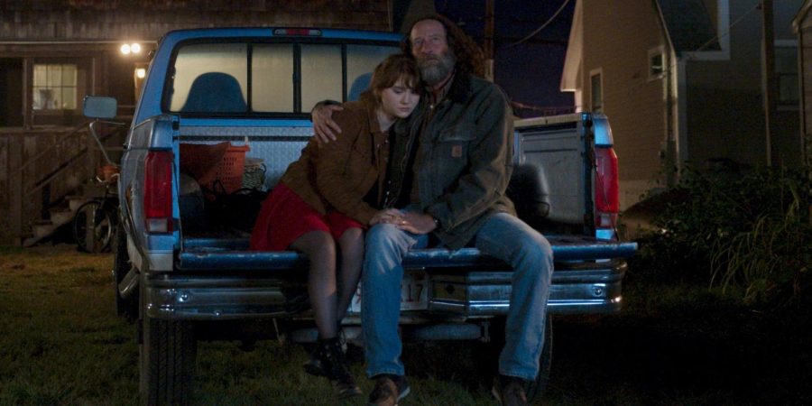 LEAN ON ME: Emilia Jones as Ruby Rossi and Troy Kotsur as her father sit in the bed of their truck in CODA, the award-winning film about a daughter who is the only hearing member in a Deaf family. 