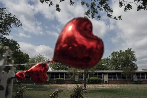 A heart-shaped balloon flies, decorating a memorial site outside Robb Elementary School in Uvalde, Texas, on Monday, May 30, 2022. In a town as small as Uvalde, even those who didnt lose their own child lost someone. Some say now that closeness is both their blessing and their curse: they can lean on each other to grieve. But every single one of them is grieving. (AP Photo/Wong Maye-E)