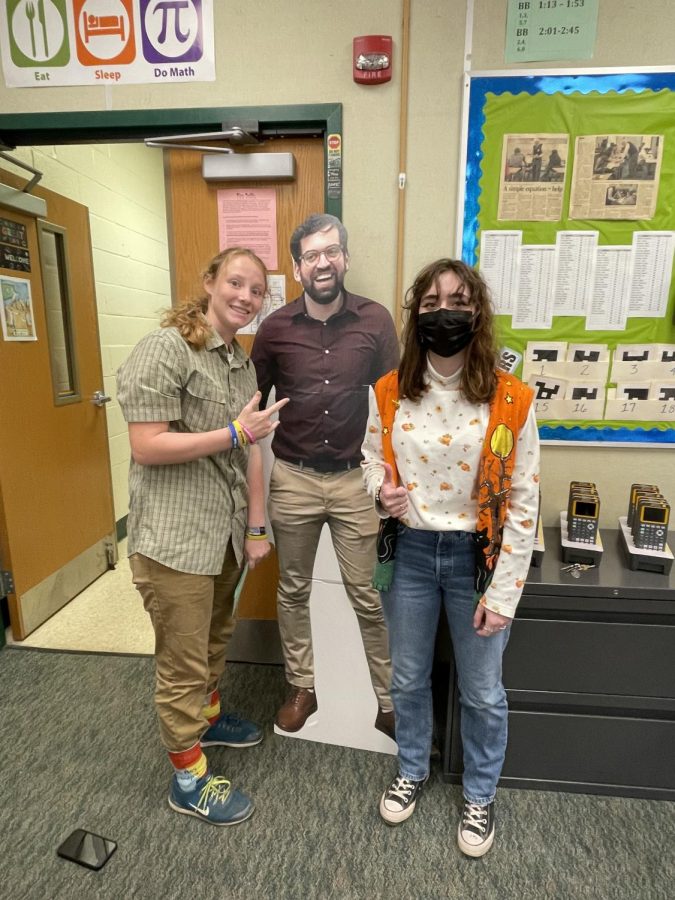Calyn Clements (left) and Jenna Coller (right) dressed as elderly people, posing with a cardboard cutout of Mr. Bigelow.