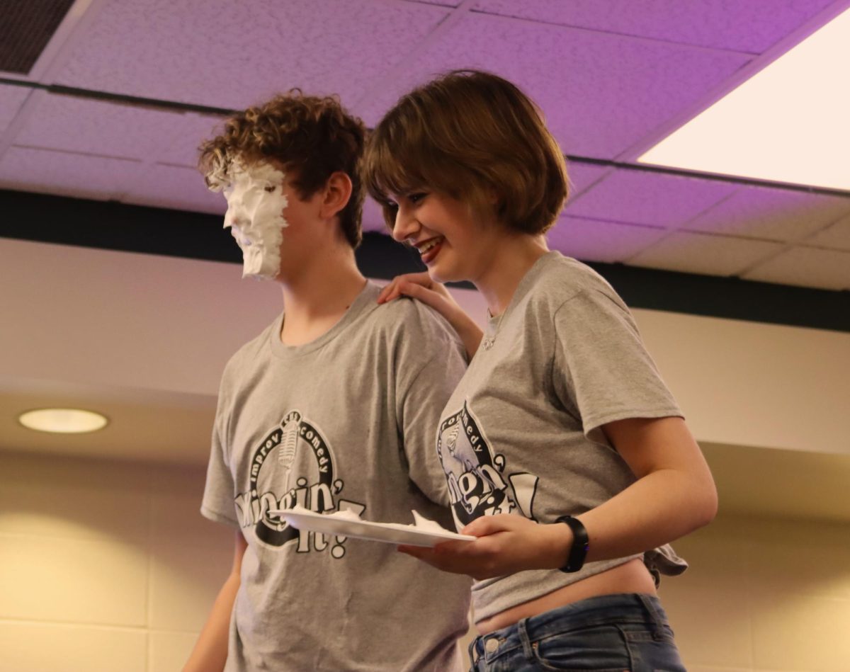 INITIATION, PART THREE: Veteran Wingman, Chase Perabo (right) walks sophomore Spencer Forrester offstage after his initiation into the troupe.