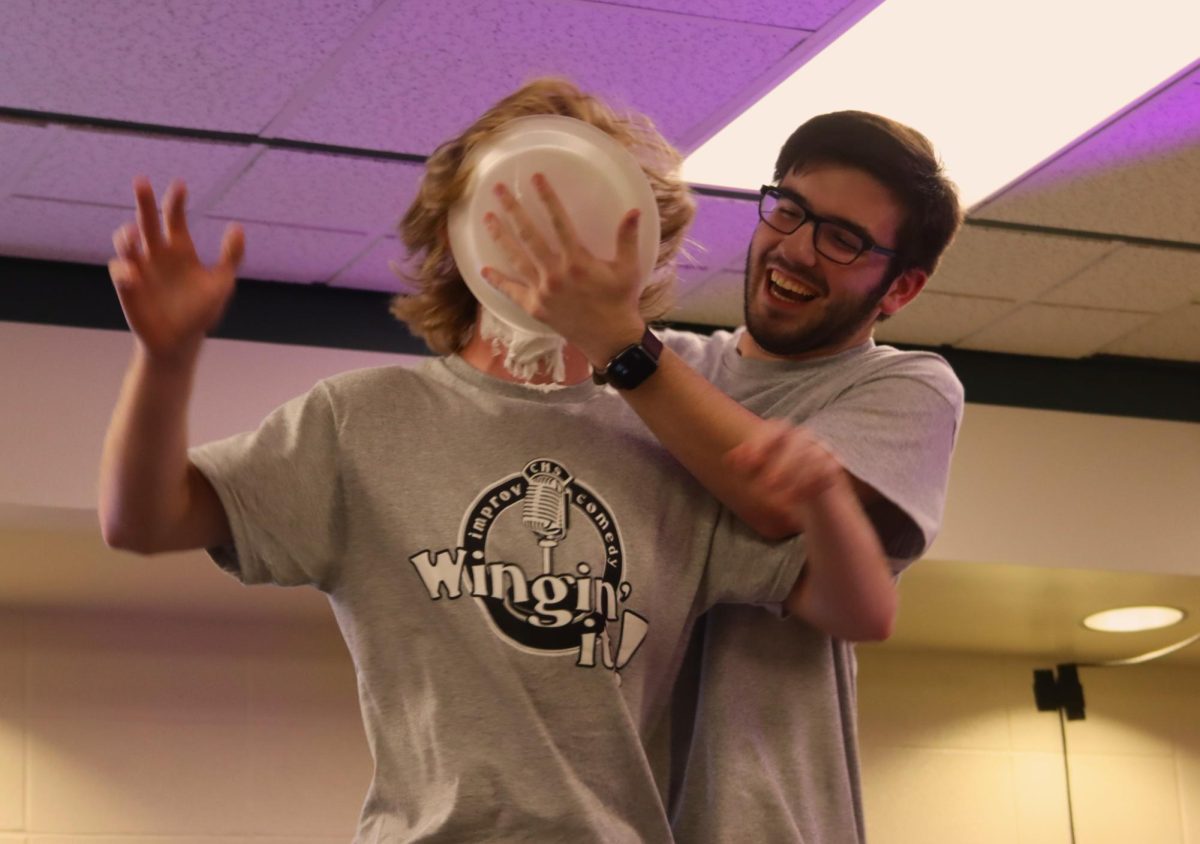 INITIATION, PART FOUR: New to the troop, junior John Forrester (left) receives a shaving-cream pie to the face from senior Aedan Shevlin (right).
