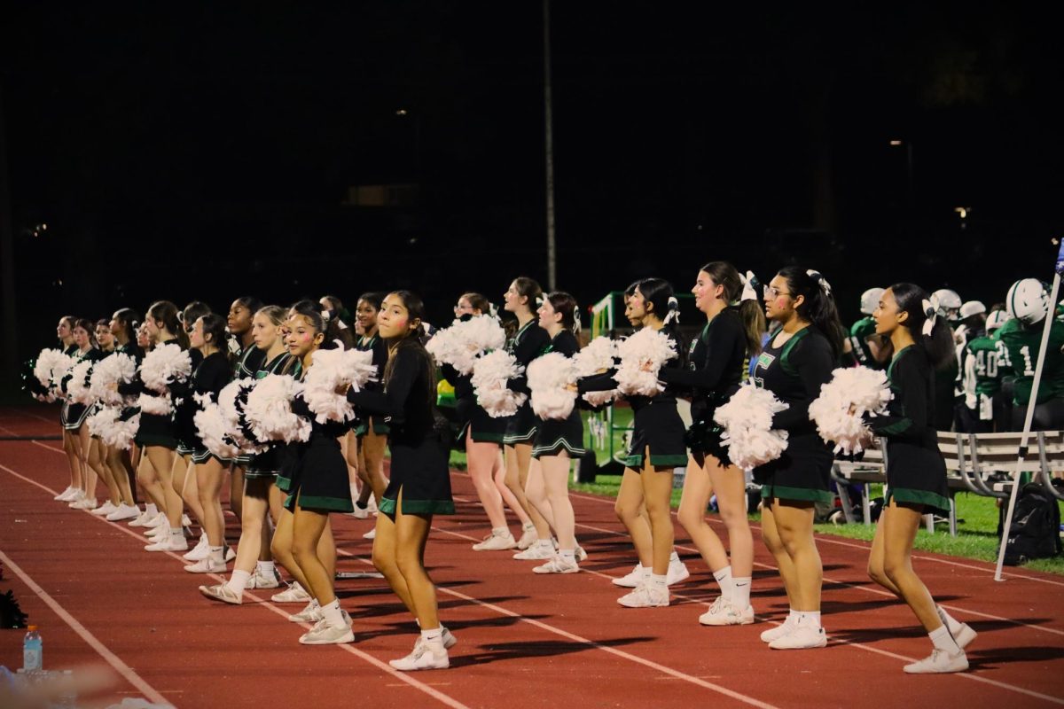 THUNDERING CHEER: Both the varsity and junior varsity cheer squads squeeze in one last chant before halftime.